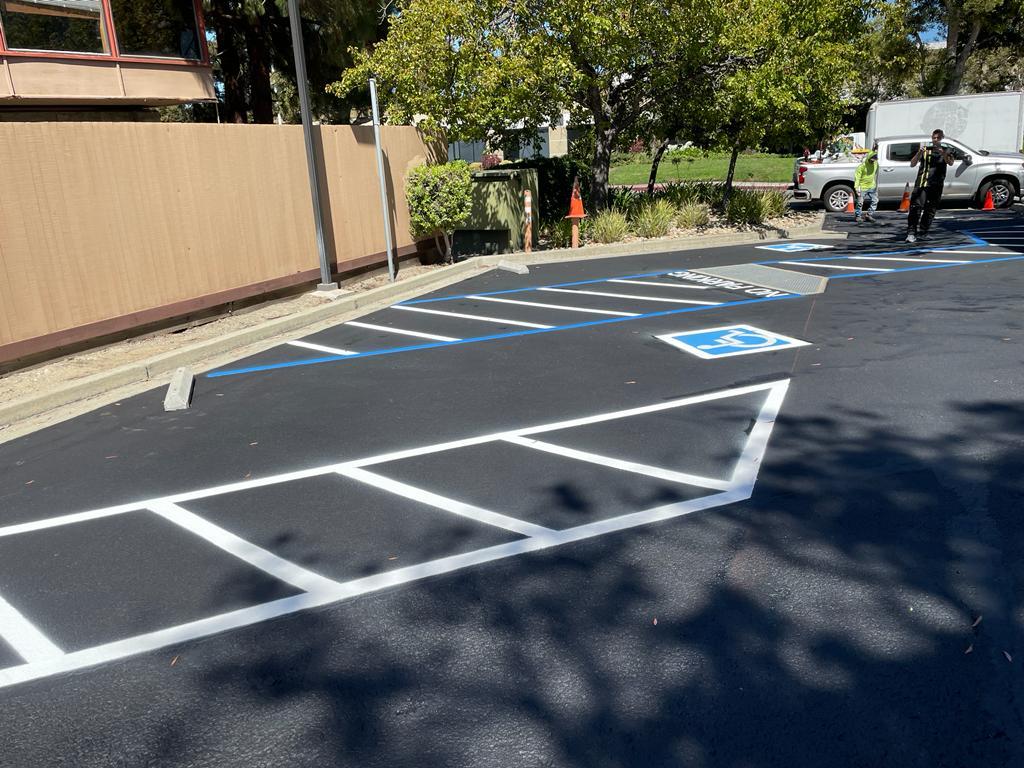 Parking lot marked with freshly painted white lines on pavement - Parking Lot Sealing and Striping