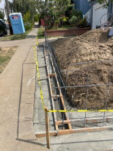 Foundation preparation for a retaining wall project with HT Paving and Sealcoating