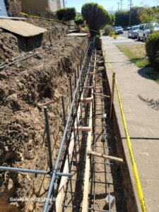 Ground excavation and leveling at HT Paving and Sealcoating's retaining wall project.