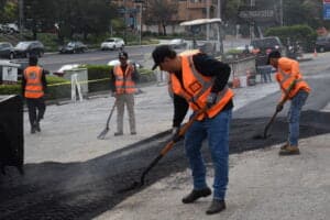 HT Paving and Sealcoating workers inspecting a newly constructed retaining wall.