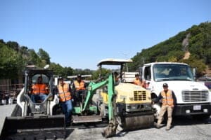 A sealcoating machine and crew members.