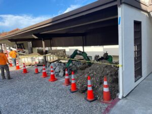 Safety signage prioritized at HT Paving and Sealcoating's retaining wall project for worker protection.