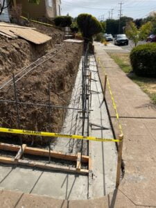 Retaining wall footing installation at HT Paving and Sealcoating's construction site.